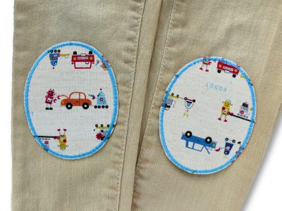 Roboter-Knieflicken auf Kinderhose aufgebügelt, naturfarbener Baumwollcanvas 8 x 10 cm mit bunten Robotern Autos und Werkzeug, Bügelflicken Kinderhosen reparieren Piratenbande Berlin