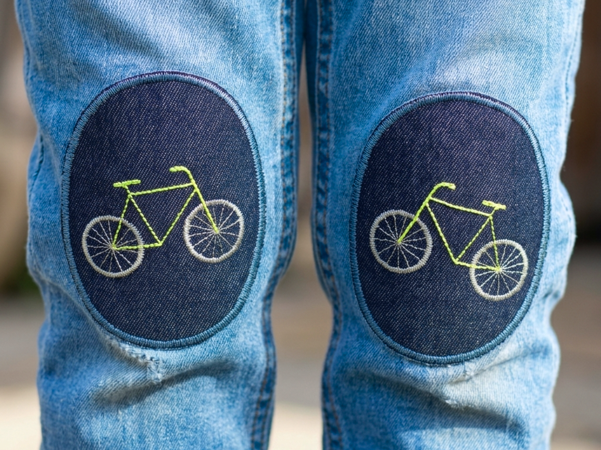 Neon-Fahrrad-Knieflicken auf Kinderhose aufgebügelt, dunkelblauer Jeansstoff 8 x 10 cm mit neonfarbendem Fahrrad gestickt, Hosenflicken Kinderhosen reparieren Piratenbande Berlin