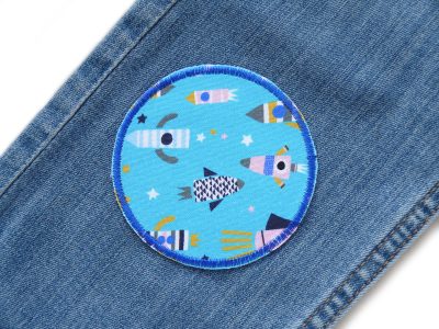 Rakete Hosenflicken hellblau Ø 8 cm auf Kinderhose aufgebügelt, Baumwollstoff mit bunten Raketen, Bügelflicken Kinderhosen reparieren handmade Berlin Piratenbande
