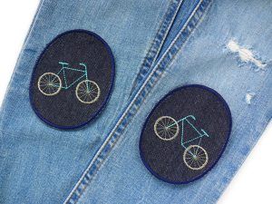 Fahrrad-Knieflicken auf Kinderhose aufgebügelt, dunkelblauer Jeansstoff 8 x 10 cm mit aquablauem Fahrrad-Motiv gestickt, Hosenflicken Kinderhosen reparieren Piratenbande Berlin