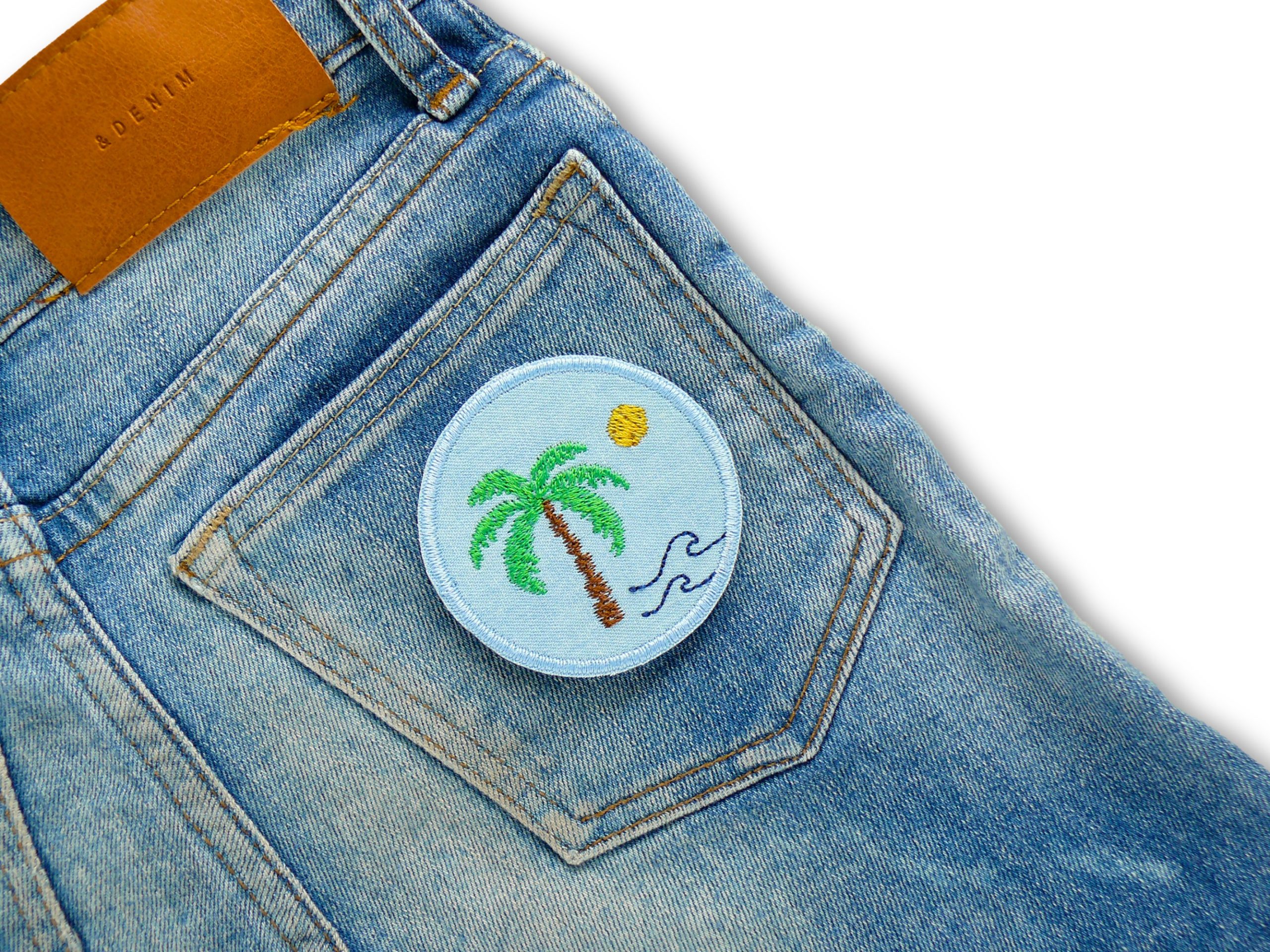 Palmen-Bügelpatch Ø 6 cm auf Gesäßtasche aufgebügelt, hellblauer Jeansstoff mit Palme und Meereswellen, Deko-Aufnäher handmade Berlin Piratenbande