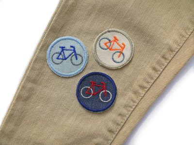 Fahrrad Aufbügler in 3 Farben auf einer Jeanshose – Mini Fahrrad Bügelflicken Ø 4 cm auf Jeanshose aufgebügelt, 3 Farbvarianten, Kinderhosen reparieren handmade Berlin Piratenbande