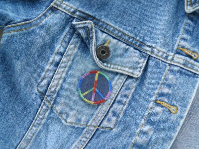 Peace Jeansflicken auf Jeansjacke aufgebügelt, Ø 4 cm, dunkelblauer Jeansstoff mit Regenbogen-Farbverlauf, gestickter Peace-Patch Statement-Aufnäher handmade Berlin