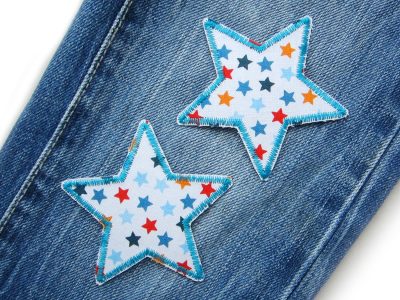Bunter Sternchen-Stern auf Kinderhose aufgebügelt, weißer Baumwollstoff 7,5 x 7,5 cm mit bunten Sternchen Allover, Bügelflicken Kinderhosen reparieren Piratenbande Berlin