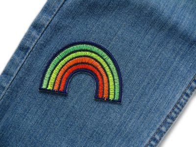 Regenbogen Bügelpatch neon auf Jeanshose, 7 x 5 cm Jeansstoff dunkelblau, Pride-Aufnäher oder Bügelflicken für Jacken und Taschen, Piratenbande Berlin