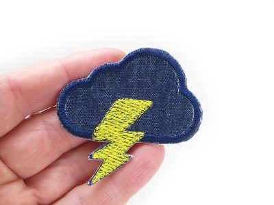Dunkelblauer Wolken-Patch mit gelbem Blitz auf Hand, gestickter Jeans-Aufnäher 5,5 cm, Bügelpatch Gewitterwolke Piratenbande Berlin