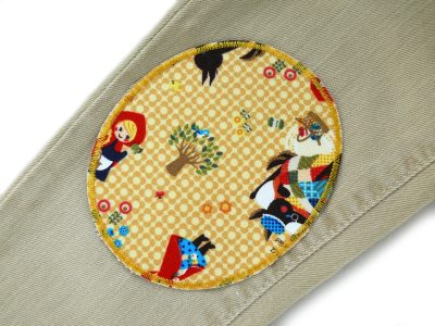Rotkäppchen-Knieflicken auf Kinderhose aufgebügelt, ockerfarbener Baumwollcanvas 10 x 12 cm mit Rotkäppchen und Wolf Allover-Muster, XL Bügelflicken Kinderhosen reparieren Piratenbande Berlin