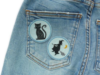 Hexe und Katze Halloween Patches auf Jeans aufgebügelt, hellblauer Jeansstoff Ø 5,5 cm mit schwarzen Silhouetten, Bügelflicken handmade Berlin Piratenbande