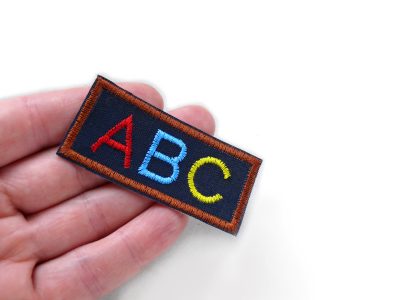 Gestickter ABC-Aufnäher aus Baumwollstoff, dunkelblau mit bunter Stickerei, 6,5 x 3 cm, Bügelpatch Schulanfang zum Aufbügeln auf Schultüte oder Jacke, Piratenbande Berlin