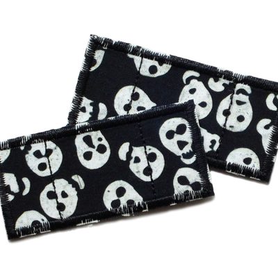 Zwei Bügelflicken in Pflasterform aus schwarzem Baumwollstoff mit hellem Totenkopf-Muster, jeweils 7,5 x 3,5 cm, zum Aufbügeln auf Kinderhosen, handmade Berlin