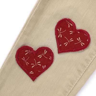 Kleine Herz-Bügelflicken weinrot mit hellen Libellen auf Hose aufgebügelt, herzförmige Libellen-Aufnäher 5,5 x 5 cm aus Baumwollstoff handmade Berlin