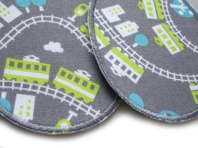 Nahaufnahme Eisenbahn-Knieflicken aus grauem Baumwollcanvas, 8 x 10 cm, bunte Züge Waggons Schienen und Häuser Allover, Bügelflicken Unikat handmade Berlin Piratenbande