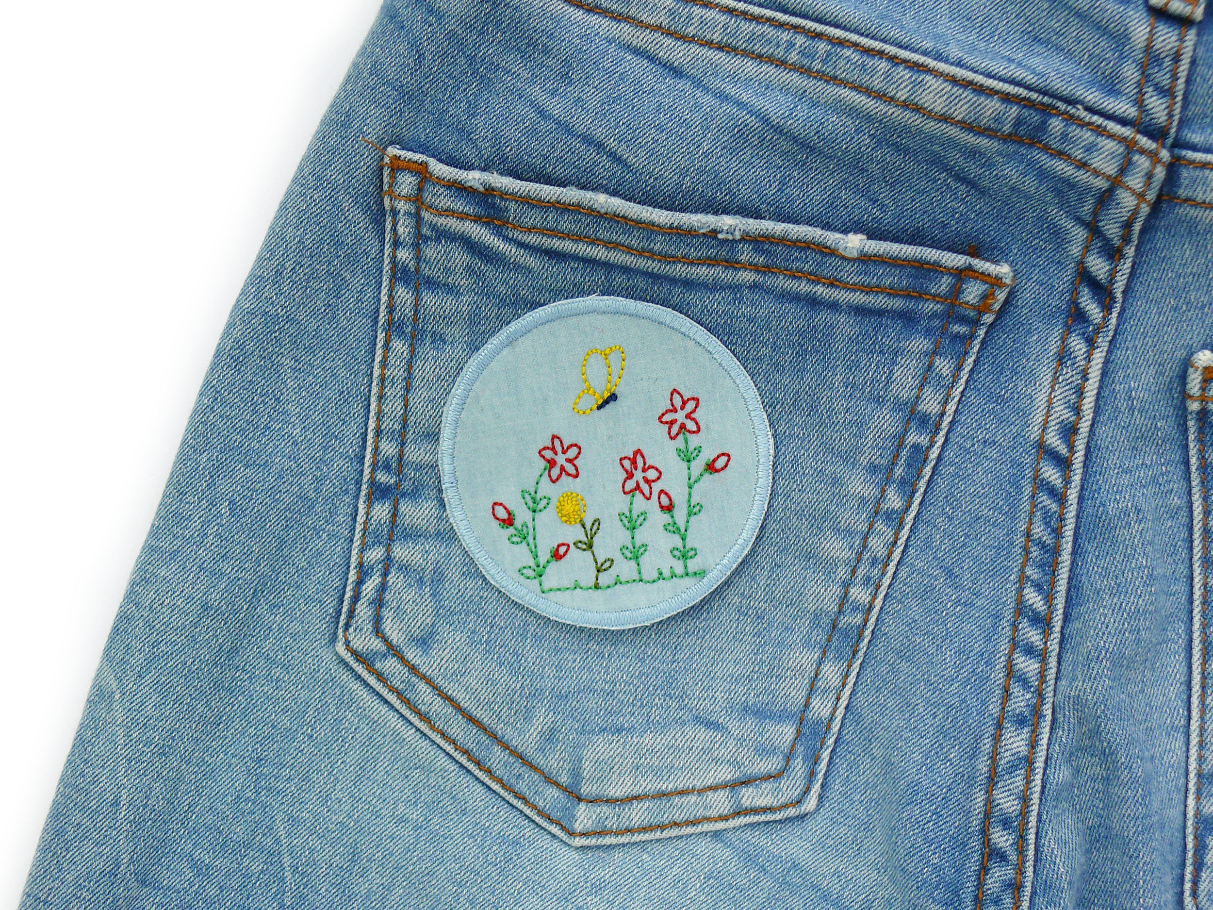 Jeanspatch mit gestickter Blumenwiese auf einer Gesäßtasche, Ø 7 c, Jeans hellblau mit gestickten Blumen und Schmetterling, Knieflicken handmade Berlin Piratenbande