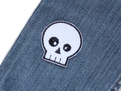 Skull Patch 5 x 5 cm auf Kinderhose aufgebügelt, weißer Baumwollstoff mit schwarz gesticktem Totenkopf, Bügelflicken handmade Berlin