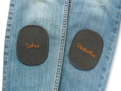 Knieflicken Tohu Wabohu 8 x 10 cm auf Kinderhose aufgebügelt, neonorange Schrift auf dunkelgrauem Canvas, Bügelflicken Kinderhosen reparieren handmade Berlin