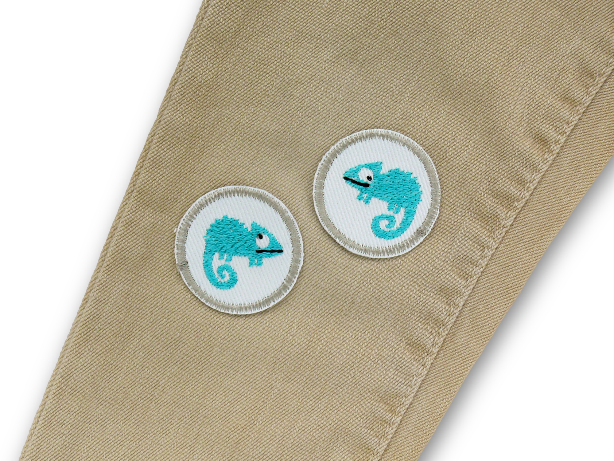 2 Chamäleon Mini Patches Ø 4 cm weißer Jeansstoff türkis, auf eine Kinderhose aufgebügelt, beide Patches nebeneinander, Chamäleon-Bügelflicken handmade Berlin Piratenbande