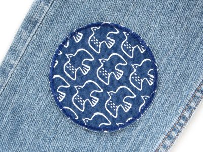 Runder Hosenflicken aus dunkelblauem Baumwollcanvas mit weißen fliegenden Vögeln auf eine Jeanshose aufgebügelt, ø 8 cm, zum Aufbügeln auf Kinderhosen und Jacken, handmade Berlin