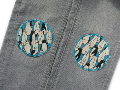 Pinguin-Bügelflicken petrol auf Kinderhose aufgebügelt, Baumwollcanvas Ø 8 cm mit Pinguin-Allover-Muster, Hosenflicken Kinderhosen reparieren Piratenbande Berlin