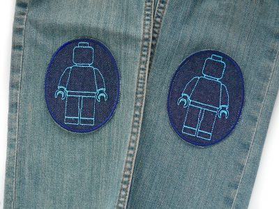 Bausteinmännchen-Knieflicken hellblau auf Kinderhose aufgebügelt, dunkelblauer Jeansstoff 8 x 10 cm mit hellblauen Spielfiguren, Bügelflicken Kinderhosen reparieren handmade Berlin