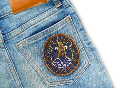 Löwen-Jeanspatch auf Gesäßtasche einer Jeanshose aufgebügelt, 6,5 x 7,5 cm dunkelblau mit gesticktem Löwenkopf, Bügelflicken Statement-Aufnäher handmade Berlin
