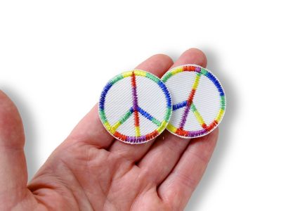 Nahaufnahme Peace-Aufnäher aus weißem Jeansstoff, Ø 4 cm, gesticktes Friedenssymbol mit buntem Regenbogen-Farbverlauf, Mini-Bügelpatch handmade Berlin Piratenbande