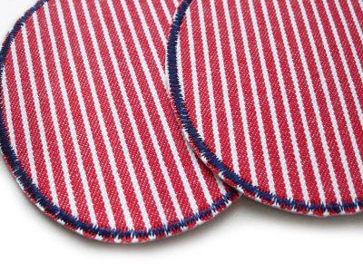 Nahaufnahme ovale Knieflicken aus rot-weiß gestreiftem Oshkosh-Jeansstoff mit dunkelblauer Umrandung, Flicken in zwei Größen erhältlich, Bügelflicken zum Aufbügeln auf Kinderhosen und Jeanshosen, handmade Berlin