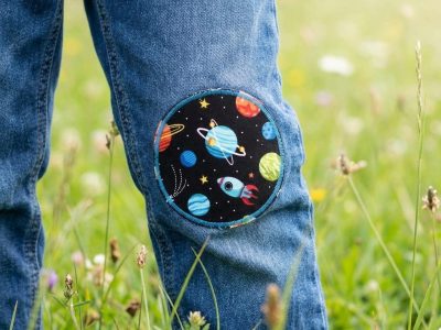 runder Hosenflicken für Kinder mit Weltall-Motiv auf einer Kinderjeans – Weltall Bügelflicken Ø 8 cm auf Kinderhose aufgebügelt, Planeten Sterne Kometen Raketen auf Schwarz, Knieflicken handmade Berlin
