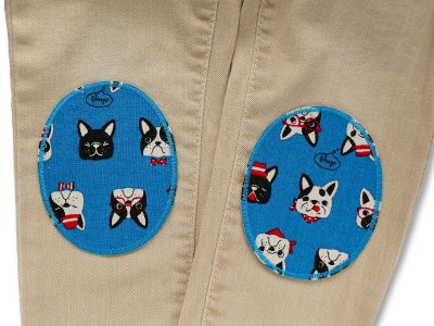 Ovale Hunde-Bügelflicken aus petrolfarbenem Baumwollcanvas auf einer hellen Jeanshose, 8 x 10 cm, bunte Hundeköpfe mit Accessoires, Knieflicken handmade Berlin Piratenbande