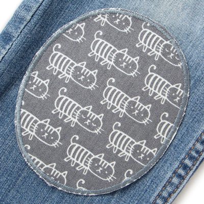Katzen-Knieflicken grau auf Kinderhose aufgebügelt, grauer Baumwollcanvas 10 x 12 cm mit weißen Katzen-Skizzen, XL Bügelflicken Kinderhosen reparieren Piratenbande Berlin