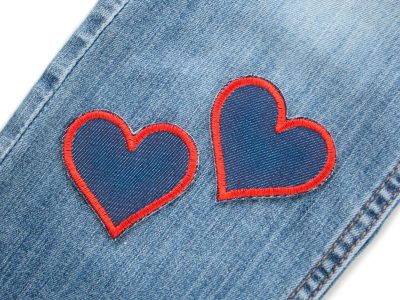 zwei kleine Herz Patches aus blauem Jeansstoff mit roter Garnumrandung auf einer Jeanshose – Herz Jeansflicken rot 5,5 x 5 cm auf Jeans aufgebügelt, Kinderhosen reparieren handmade Berlin Piratenbande