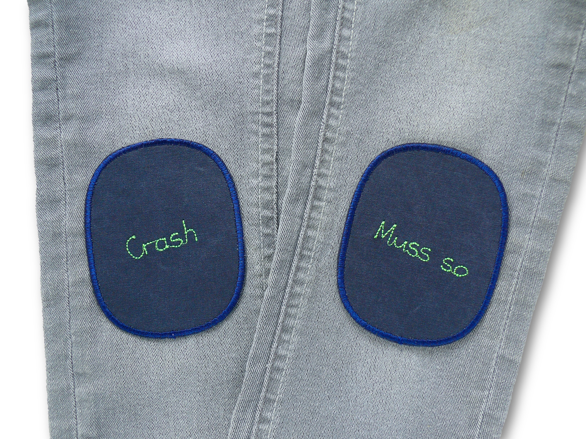 Knieflicken Crash und Muss so 8 x 10 cm auf Kinderhose aufgebügelt, neongrüne Schrift auf dunkelblauem Canvas, Bügelflicken Kinderhosen reparieren handmade Berlin