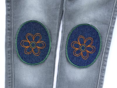 Blumen-Knieflicken auf Kinderhose aufgebügelt, dunkelblauer Jeansstoff 8 x 10 cm mit großer gestickter orange Blüte, Hosenflicken Kinderhosen reparieren Piratenbande Berlin