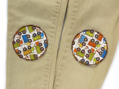 Laster Hosenflicken Ø 8 cm auf Kinderhose aufgebügelt, heller Baumwollstoff mit bunten LKW und brauner Umrandung, Bügelflicken handmade Berlin Piratenbande