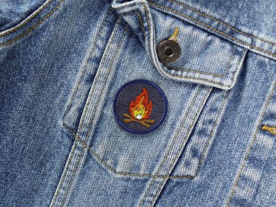 Mini Lagerfeuer Patch auf einer Jeansjacke, Ø 4 cm Jeans-Aufnäher mit Feuermotiv Rot Orange Gelb auf Dunkelblau, Camping-Patch oder Bügelflicken handmade Berlin Piratenbande