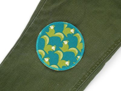 Eichhörnchen-Bügelflicken petrol auf Kinderhose aufgebügelt, Baumwollcanvas Ø 8 cm mit grünen Eichhörnchen, Knieflicken Kinderhosen reparieren Piratenbande Berlin