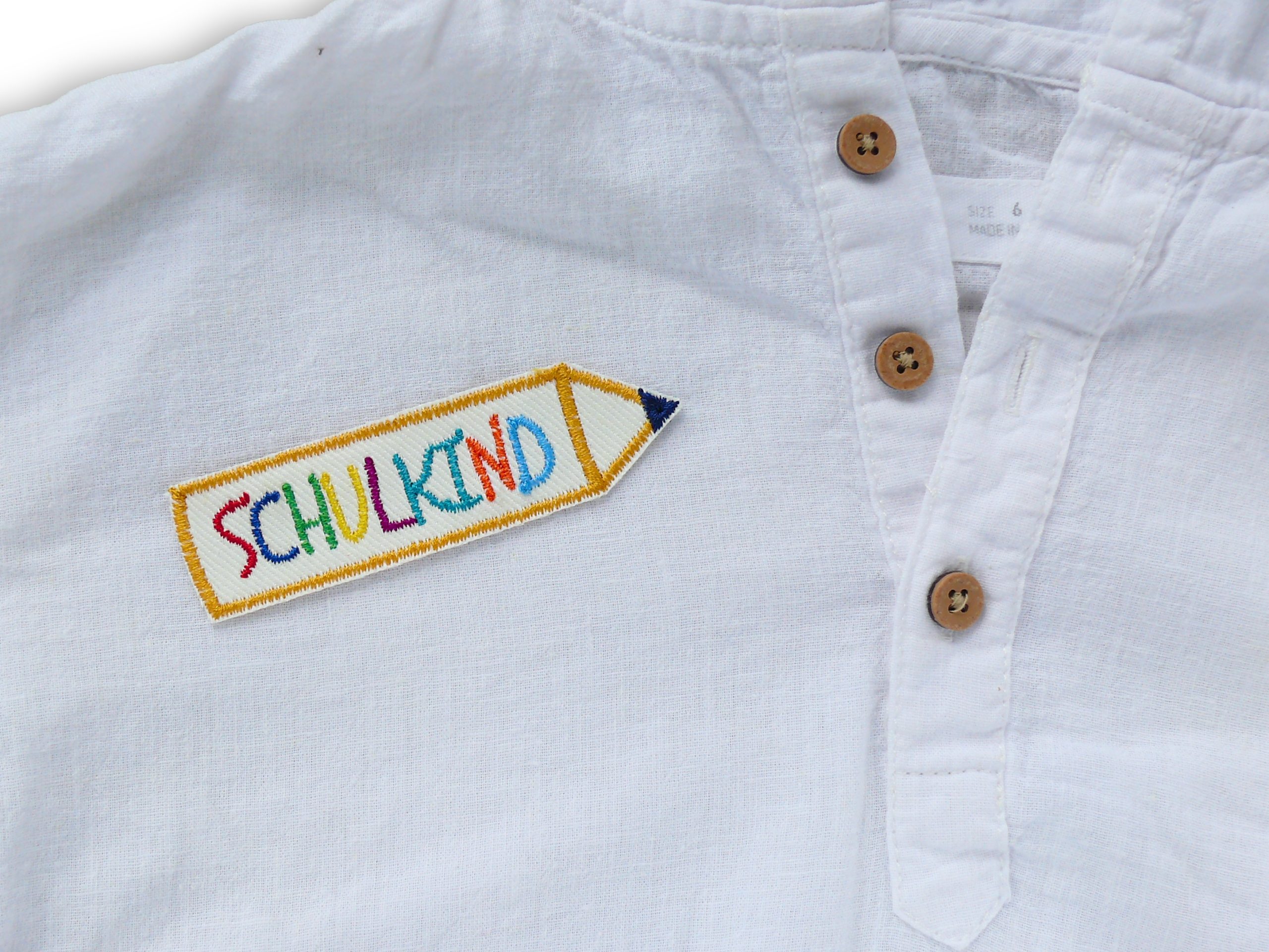 Schulkind Bügelpatch auf Shirt aufgebügelt, weißer Jeansstoff 9 x 2,5 cm mit bunter Stickerei, Einschulungs-Aufnäher handmade Berlin Piratenbande