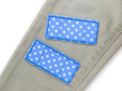 2 Hosenpflaster aus hellblauem Baumwollstoff mit weißen Sternchen auf eine helle Jeanshose aufgebügelt, jeweils 7,5 x 3,5 cm Pflasterform, Bügelflicken für Minilöcher in Kinderhosen und Shirts handmade Berlin