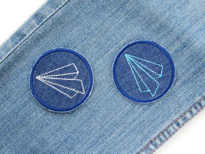 Papierflieger-Aufnäher auf Jeanshose, dunkelblauer Jeans-Patch Ø 5 cm mit Papierflieger-Stickerei, Mini-Bügelflicken zum Aufbügeln, Piratenbande Berlin