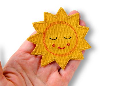 Nahaufnahme gesticktes Sonnengesicht auf gelbem Baumwollcanvas, 8 x 8 cm, Sonne Bügelpatch Aufnäher handmade Berlin