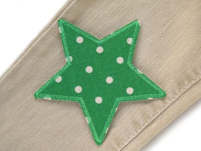 Grasgrüner Pünktchen-Stern auf Jeanshose aufgebügelt, Baumwollcanvas 10 x 10 cm mit hellen Punkten, Stern-Bügelflicken Hosenflicken Kinderhosen reparieren Piratenbande Berlin