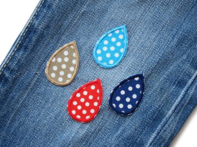 Mini Regentropfen Bügelflicken 4er Set auf eine jeanshose aufgebügelt, Baumwoll-Aufnäher 3,5 x 2,5 cm in vier Farben mit weißen Punkten, Tropfen-Patches handmade Berlin Piratenbande