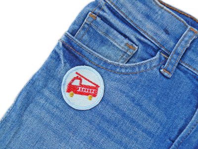 Mini Feuerwehr Patch hellblau auf Kinderhose aufgebügelt, hellblauer Jeansstoff Ø 4 cm mit rotem Feuerwehrauto, Bügelflicken Kinderhosen reparieren handmade Berlin Piratenbande