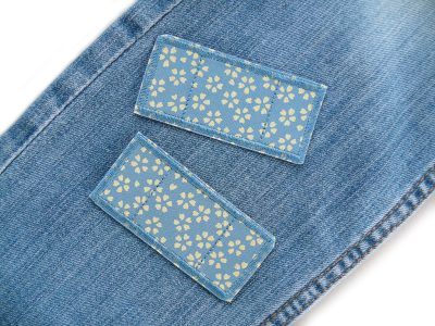 Blüten-Trostpflaster auf Kinderhose oder Jeans aufgebügelt, graublauer Baumwollstoff 7,5 x 3,5 cm mit hellen Blüten, Hosenpflaster Bügelflicken handmade Berlin Piratenbande