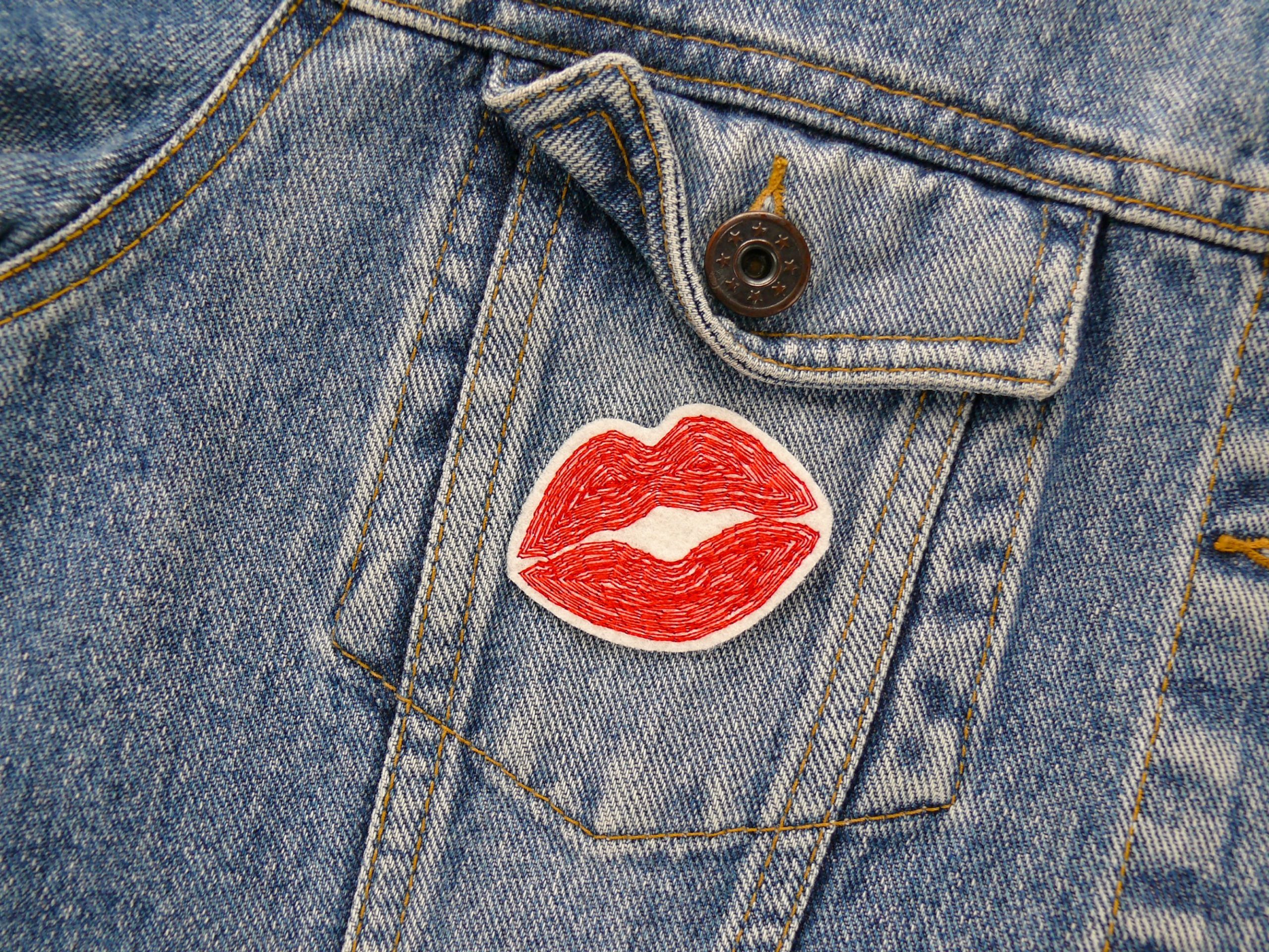 Kussmund Bügelbild auf Jeansjacke aufgebügelt, naturfarbener Filz 5 x 3,5 cm mit roter Lippenstickerei, Lippen-Aufnäher handmade Berlin