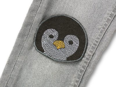 Pinguin-Hosenflicken dunkelgrau auf Kinderhose aufgebügelt, 8,5 x 7,5 cm, gesticktes Pinguin-Gesicht in Weiß und Gelb, Knieflicken Aufnäher handmade Berlin Piratenbande
