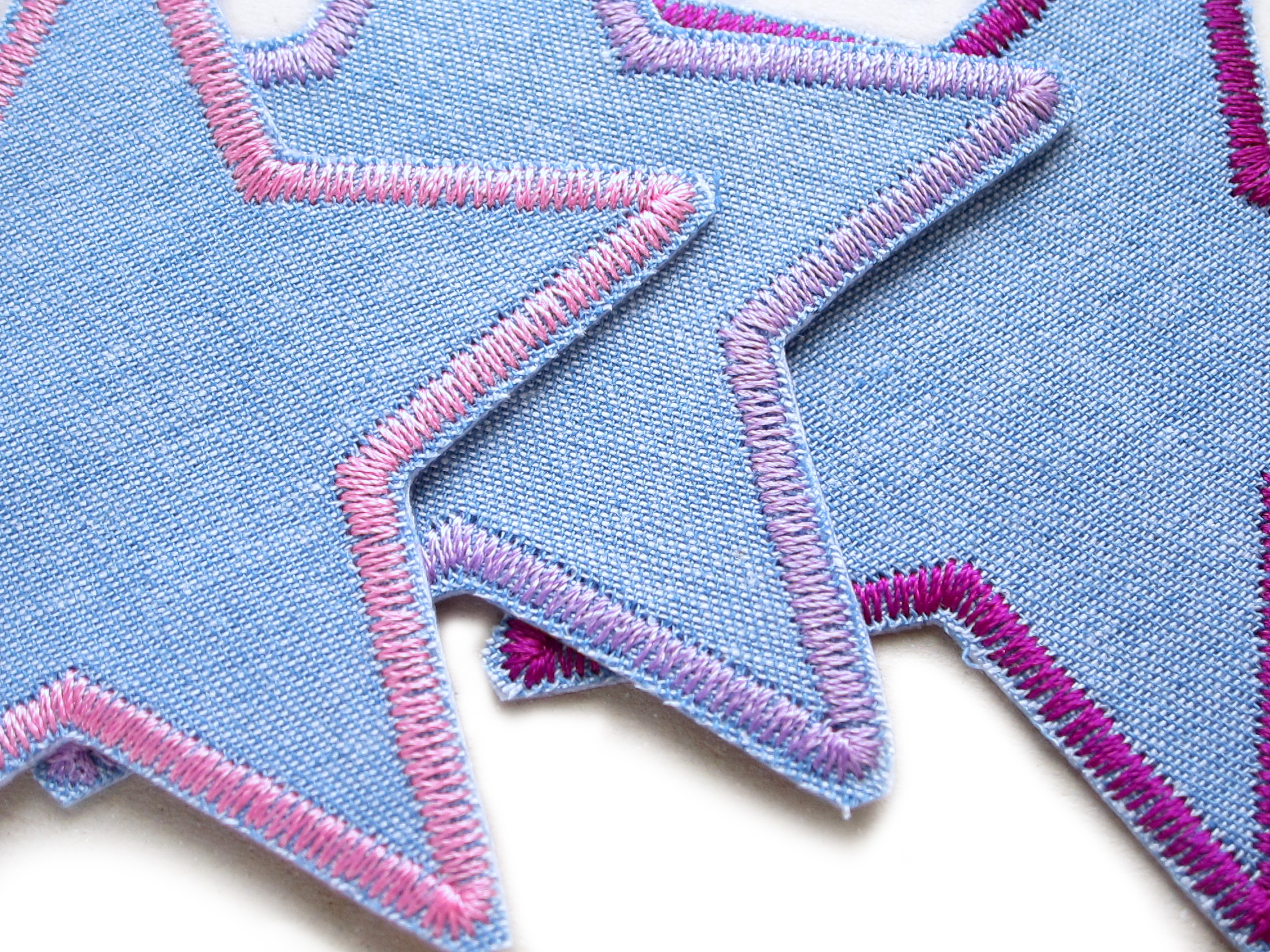 Nahaufnahme Stern-Bügelflicken mit rosa lila flieder Garnumrandung auf mittelblauem Jeansstoff, 8 x 8 cm, Stern-Aufnäher Set handmade Berlin Piratenbande