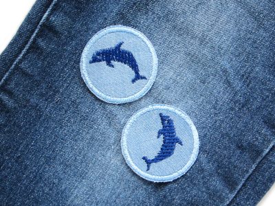Mini Delfin-Patch auf Jeanshose aufgebügelt, hellblauer Jeansstoff Ø 4 cm mit dunkelblauem gesticktem Delfin, Mini-Bügelflicken oder maritimer Aufnäher handmade Berlin Piratenbande