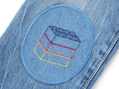 Bausteine-Knieflicken auf Kinderhose aufgebügelt, mittelblauer Jeansstoff 8 x 10 cm mit gestickten Bausteinen in Dunkelblau Rot Gelb, Hosenflicken Kinderhosen reparieren Piratenbande Berlin