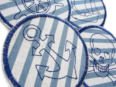 Piraten Flicken zum aufbügeln in 4 Motiven – Nahaufnahme 4 Piraten Bügelflicken Ø 8 cm graublauer Canvas mit dunkelblauer Stickerei, Piraten-Knieflicken handmade Berlin Piratenbande