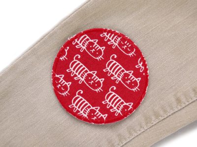 Roter Katzen-Hosenflicken auf Kinderhose aufgebügelt, Baumwollcanvas Ø 8 cm mit weißen Katzen, Bügelflicken Kinderhosen reparieren Piratenbande Berlin